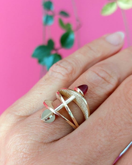 Geelgouden ring Cupido met roze toermalijn Geelgouden ring Cupido met roze toermalijn in een ontwerp van drie vloeiende banden met hierdoor een pijl.